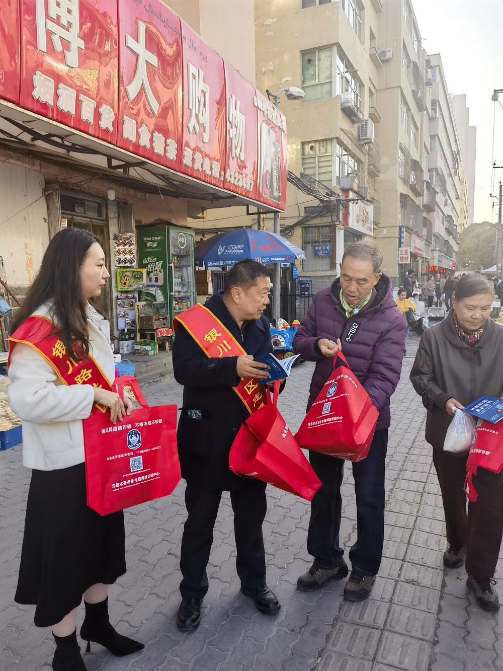 5.左1社会服务专委会副秘书长马筱薇，左2社会服务专委会委员查峰，现场向群众进行宣讲.jpg